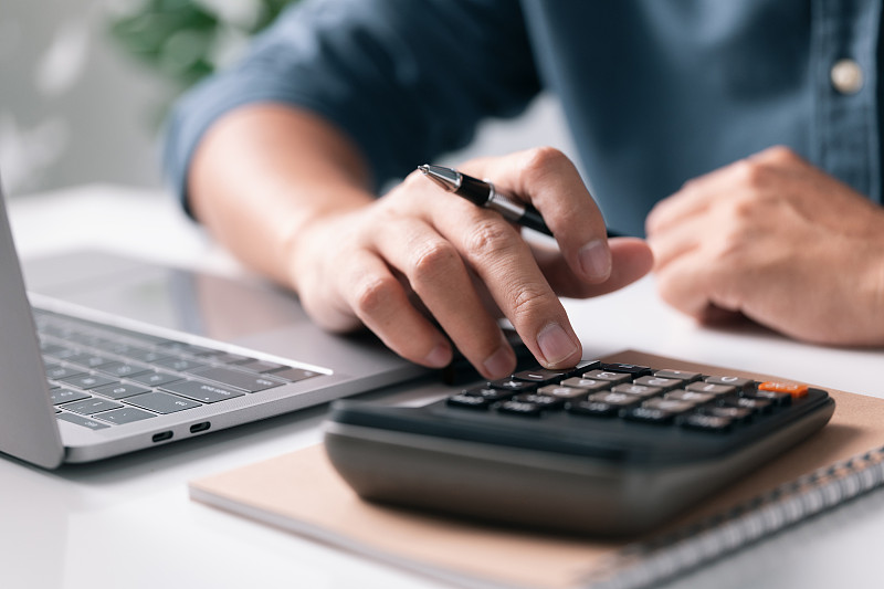 男人用计算器计算财政和税费。商业分析会计概念