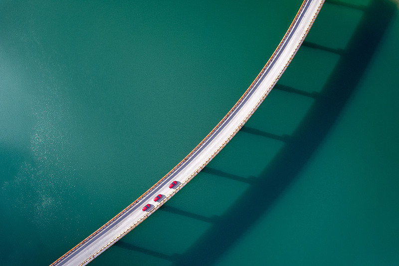 在湖上的桥上看树红色的汽车