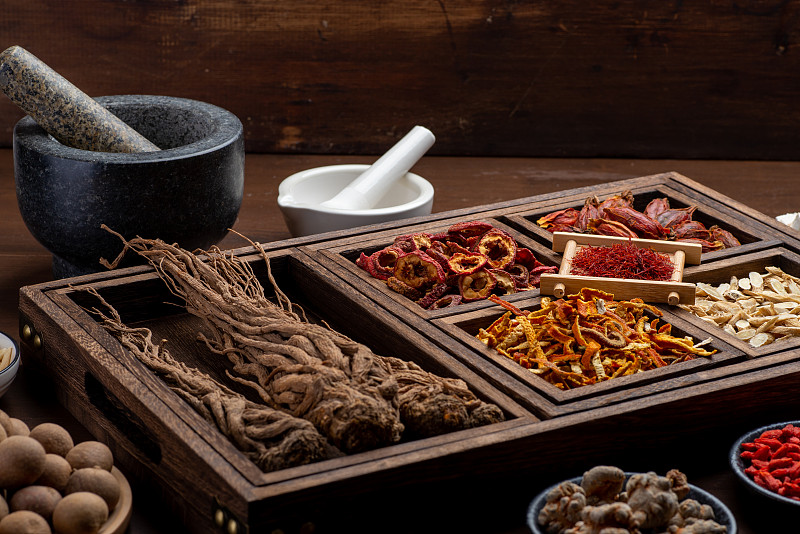 桌上放着古老的中医书籍和药草