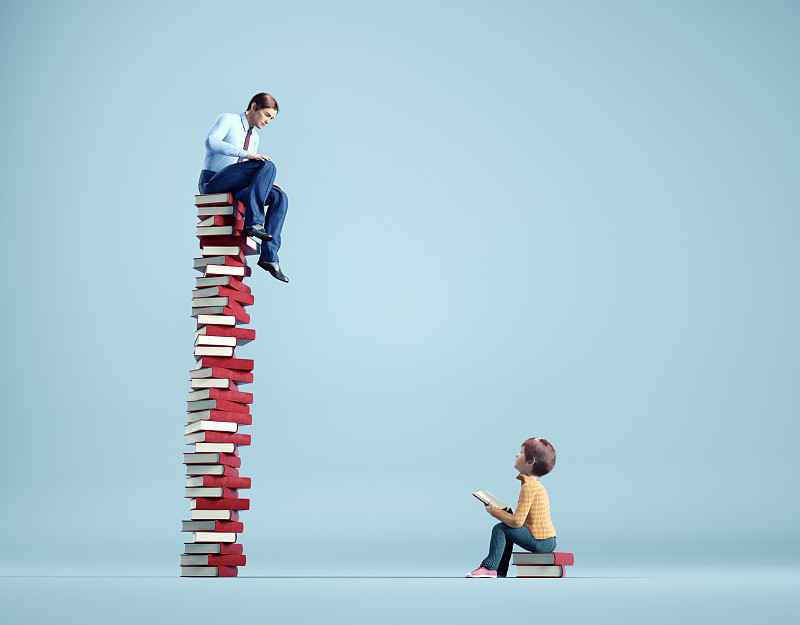 在一堆书里的孩子会仰望一个在更大一堆书里的成年人。老师和学生。