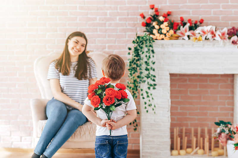 背后拿着一束花的男孩