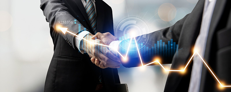 客户与投资者的握手或成功商人的手握手后，成功的谈判和合同与财务图表，伙伴关系和合作理念
