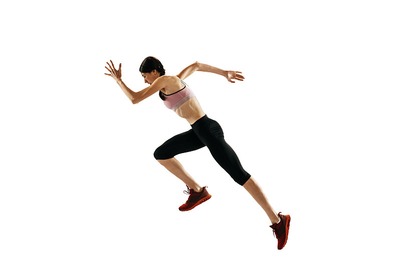 年轻的白人女性在白人摄影棚里独自奔跑。一名女性跑步者或慢跑者。体育、田径、竞技概念