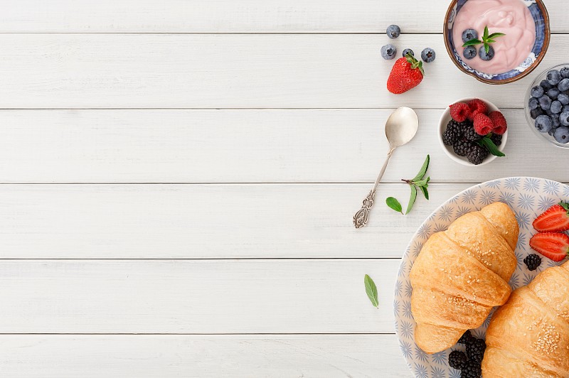 欧式早餐，有羊角面包和格子布上的浆果