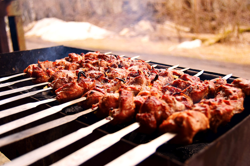 用烤肉串在煤上烤，用烟熏，柔和的焦点。烧烤季节开始了