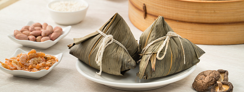 粽子端午节粽子放在明亮的木桌上，以窗为背景。