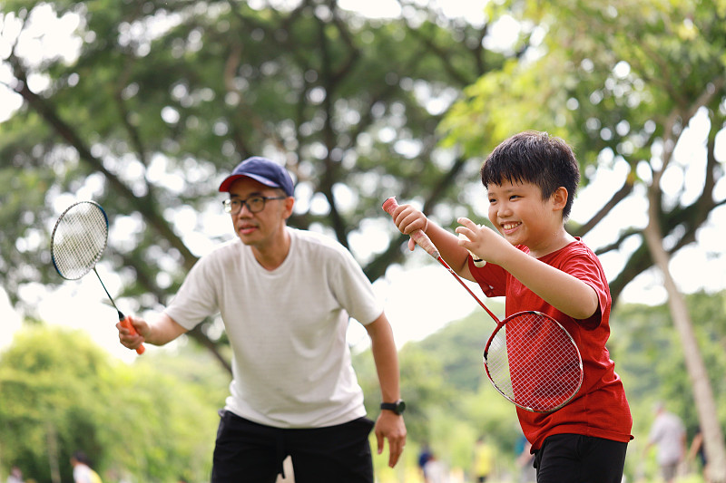 父子俩在公园里打羽毛球