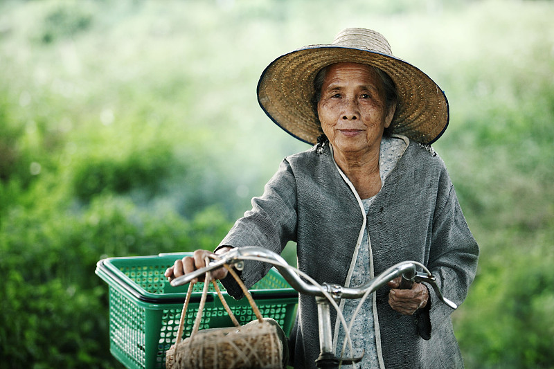 老年妇女夫妇在户外骑着自行车