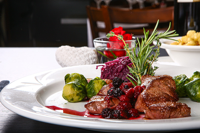 用白色盘子盛有肉和蔬菜的正餐