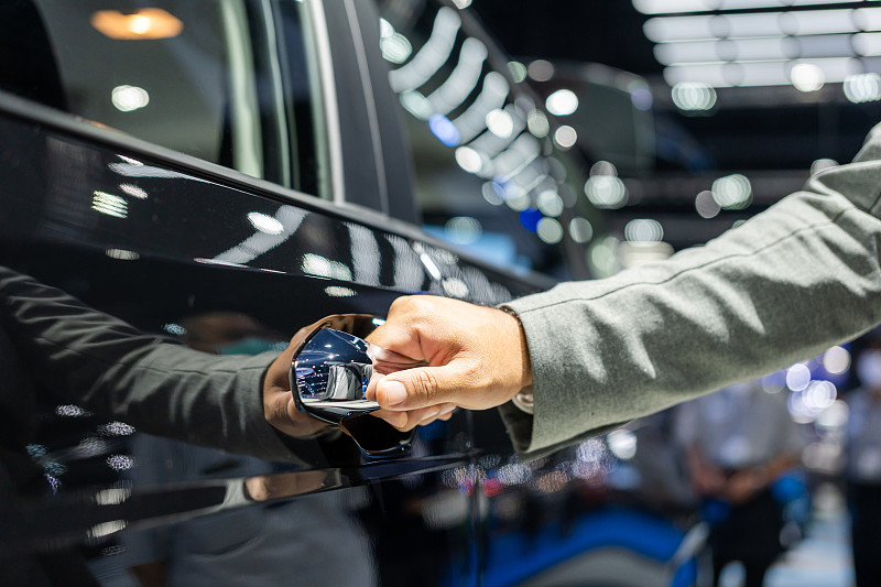 关闭男手按无钥匙按钮，手握车门打开车门。