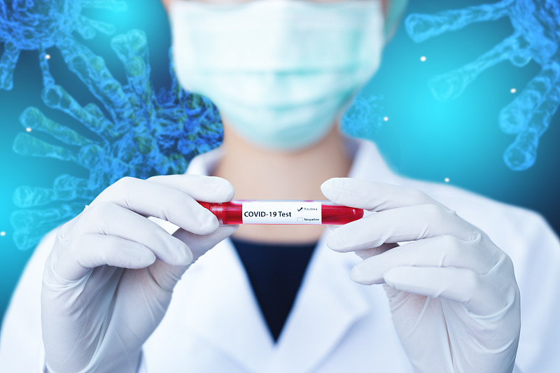 医生拿着冠状病毒血样管，在抽象病毒蓝色背景上感染