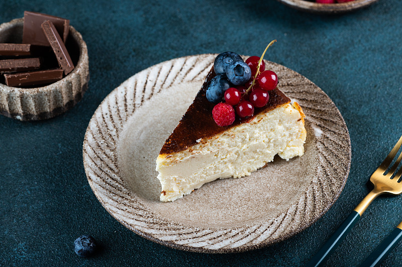 一块加浆果的圣塞巴斯蒂安巴斯克芝士蛋糕。巴斯克芝士蛋糕。受欢迎的甜点。烧芝士蛋糕。