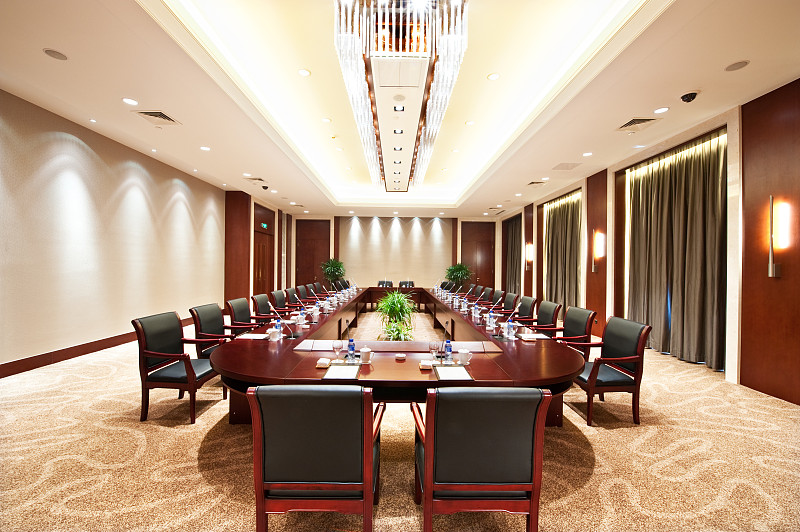 有一张长桌子和许多椅子的会议室