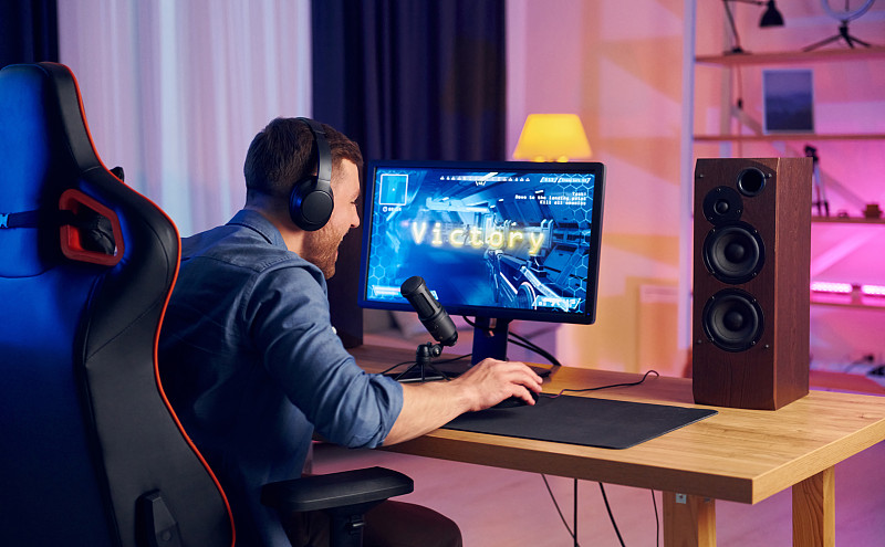 视图从后面。在线主播在家玩FPS射击游戏