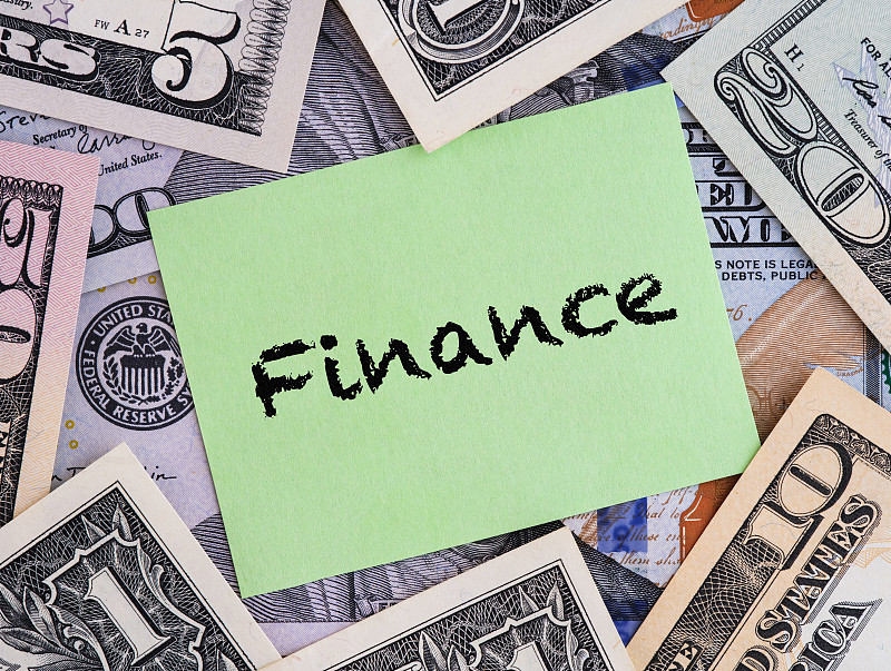 绿纸钞票，背景是美元钞票，印有“金融”字样。