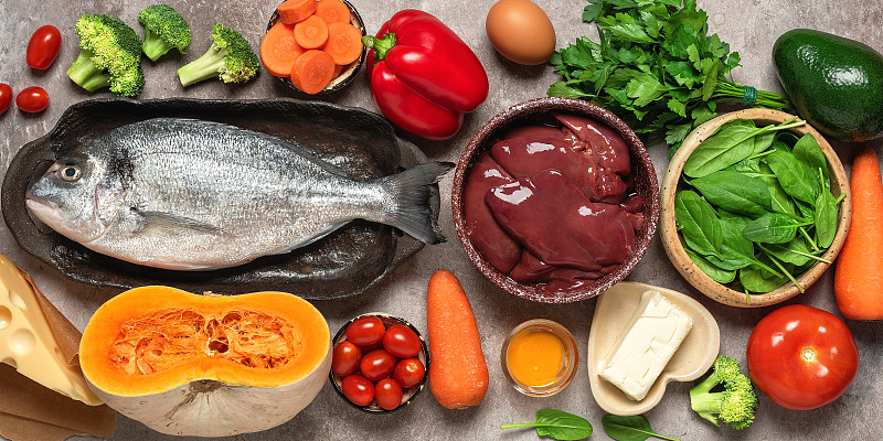 健康均衡的食物背景，横幅。富含维生素a的食物:火鸡肝，蔬菜，新鲜的鱼，黄油和奶酪。俯视图，平放。