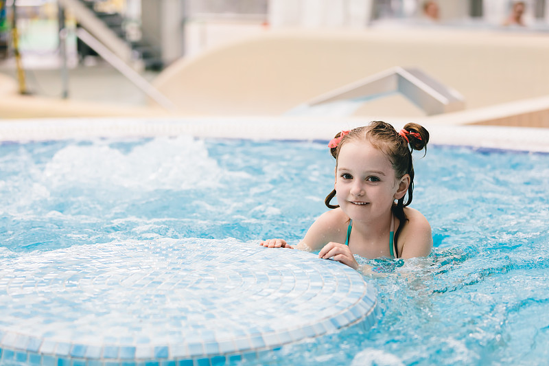快乐的小女孩在热水浴缸里玩。