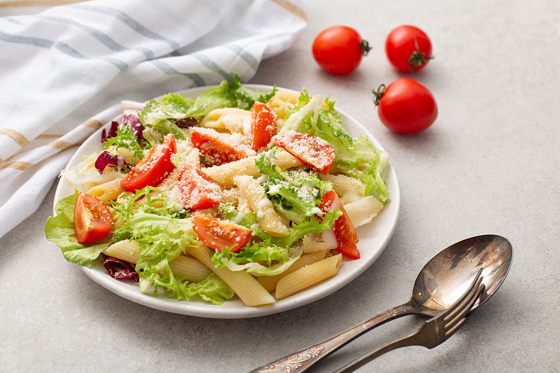 有机素食沙拉番茄和生菜，俯视图。Deliciosu面食板。生素食通心粉。意大利的健康食品。
