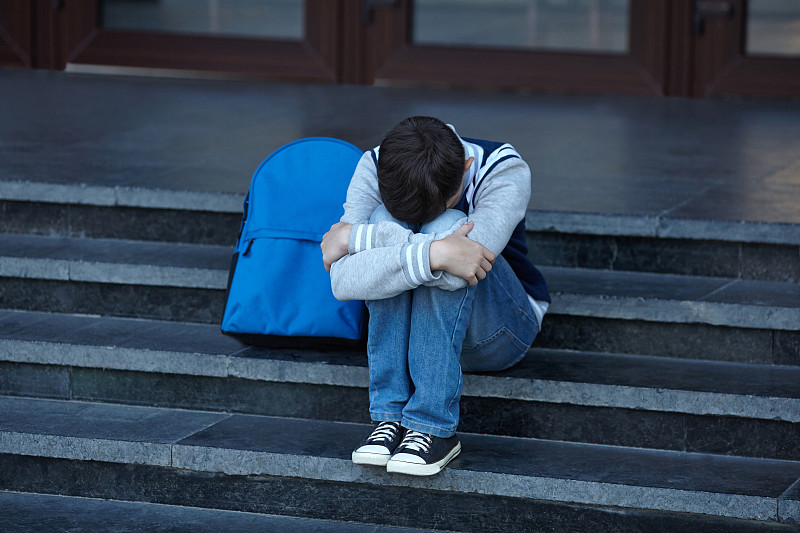 一个男生在学校的院子里哭