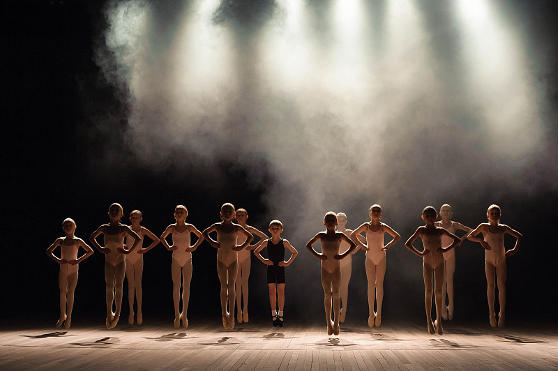 年轻的芭蕾舞演员在芭蕾课上排练。他们表演不同的舞蹈动作，站在不同的位置