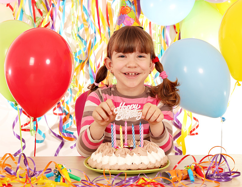 快乐的小女孩与蛋糕和气球生日聚会
