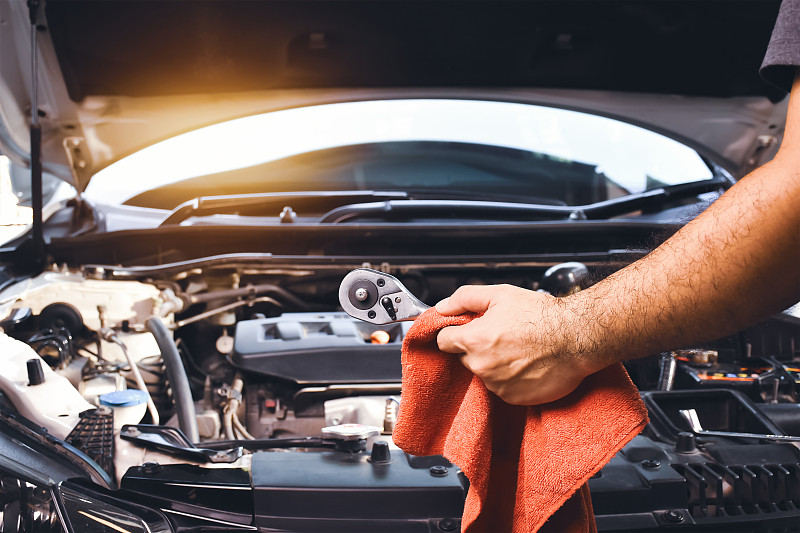 汽车机械师手拿扳手和红布