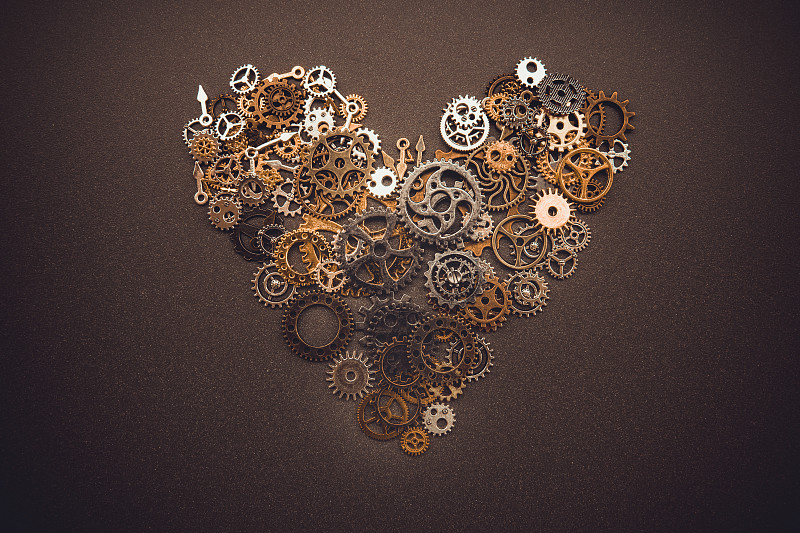 心形符号从旧的黄铜齿轮孤立在抛光的背景