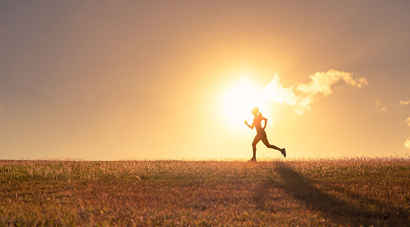日落时奔跑的女性。