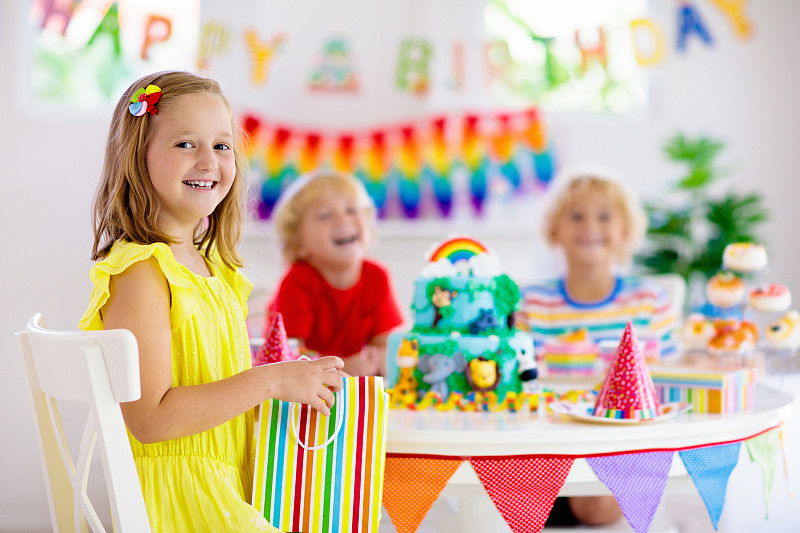 孩子的生日聚会。孩子们在蛋糕上吹蜡烛。