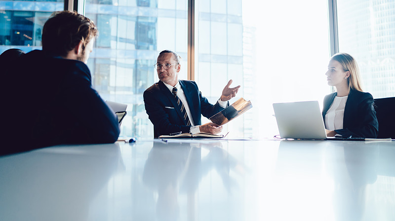 男主管在办公室与同事进行简报