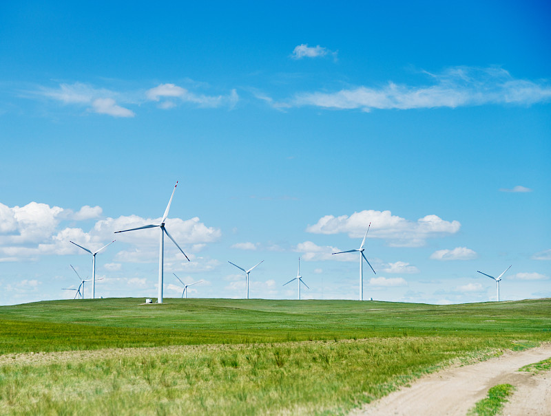 草地上有土路和风力发电机