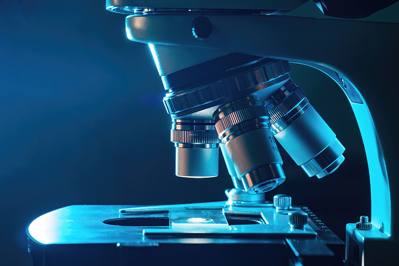 夜间实验室的显微镜。微生物学和研究概念。