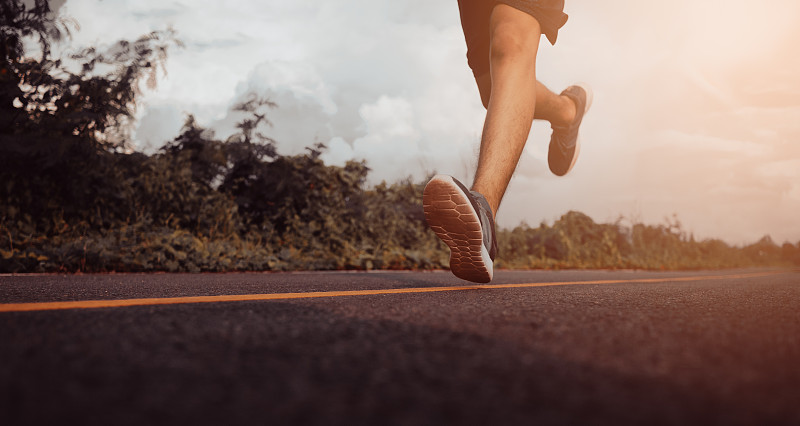 十几岁的男孩在街上跑步锻炼身体。近距离的腿部。健康的生活方式的概念。