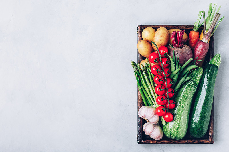 新鲜有机蔬菜装在一个木制盒子里，顶视图与复制空间。