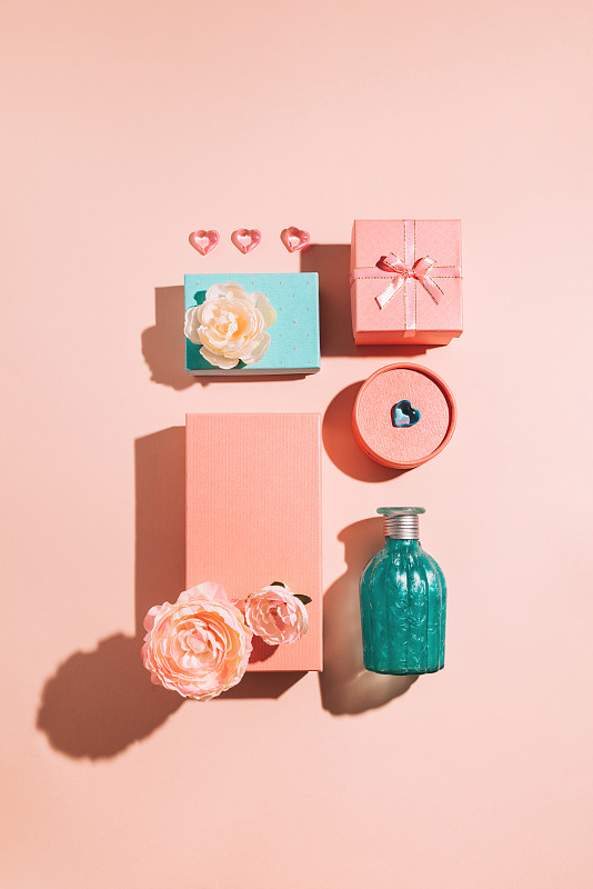 节日的几何礼盒和鲜花的安排，柔和的颜色与阳光的阴影