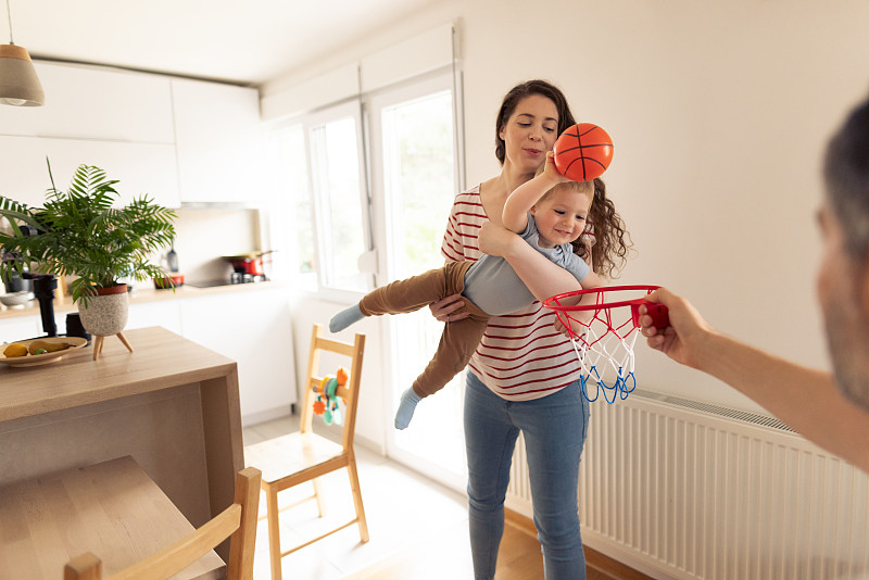 一个白人家庭在家里打篮球