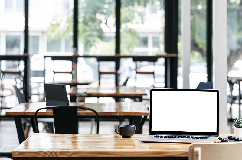 木桌上的黑屏笔记本电脑。