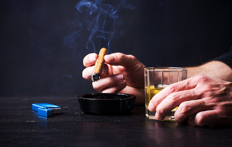 一个男人在酒吧喝酒抽烟