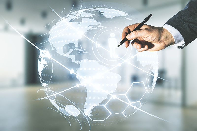 人的手与笔工作与虚拟社会网络全息图和世界地图在模糊的办公室背景。Multiexposure