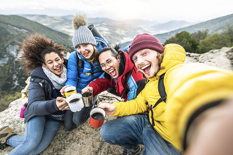 多种族的年轻人一起登山-快乐的朋友在悬崖顶上自拍-徒步旅行，旅行和运动的概念