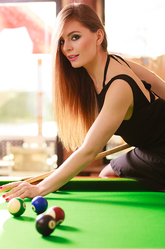 年轻时尚的女孩打台球。