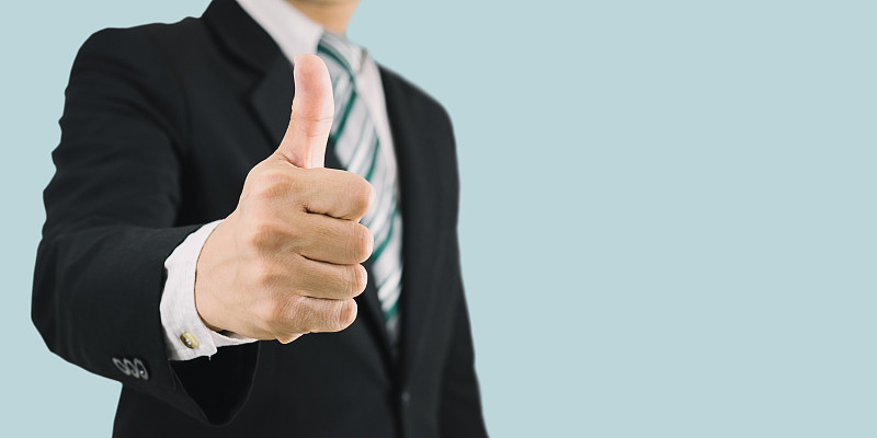 穿着黑色西装的商人竖起大拇指