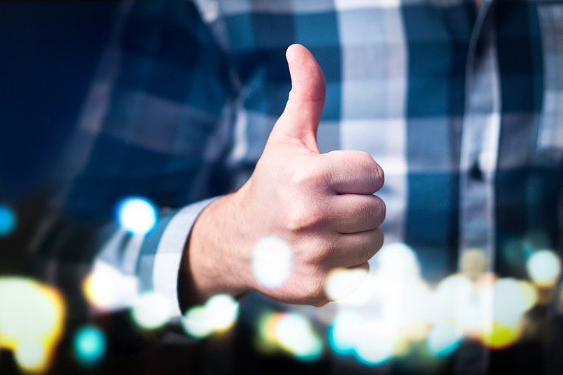 男人在现代和抽象的空间中表现出大拇指。