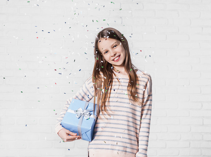 派对上飘落五彩纸屑的快乐女孩