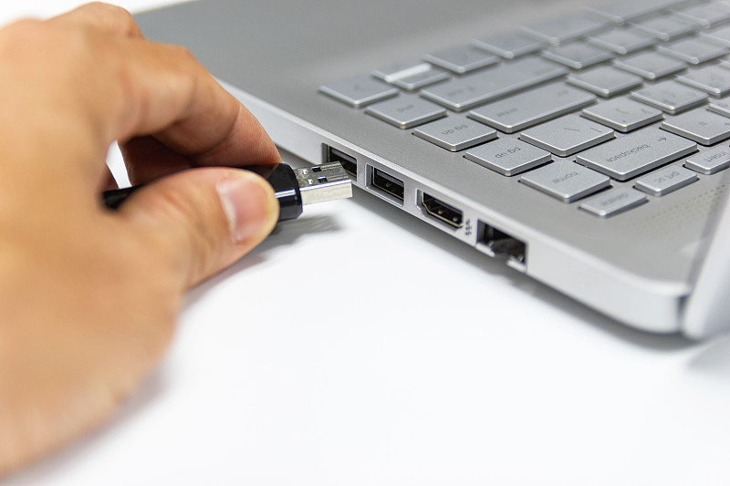 手握闪存驱动器连接USB端口插件电脑笔记本电脑传输数据