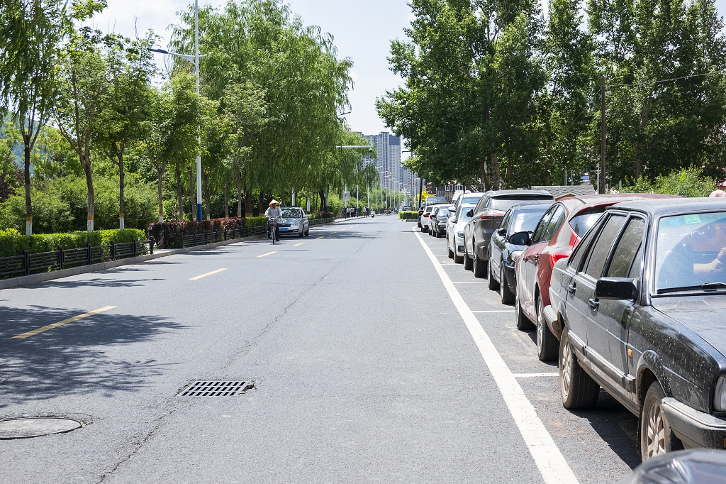 城市街道一旁停满汽车