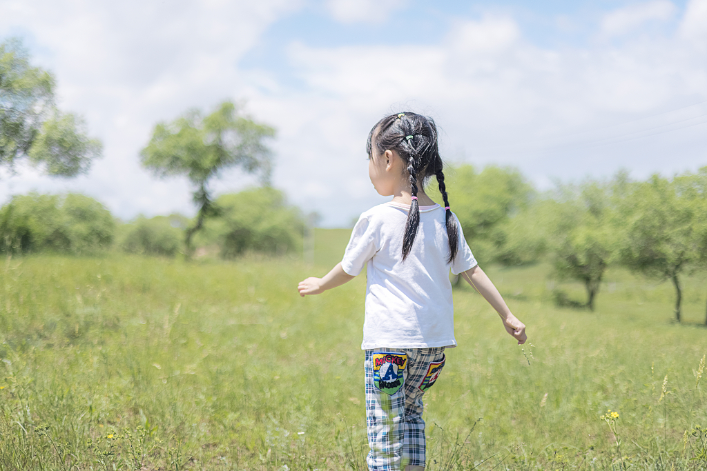 夏天草地上玩耍的女孩童真童趣童年户外儿童摄影