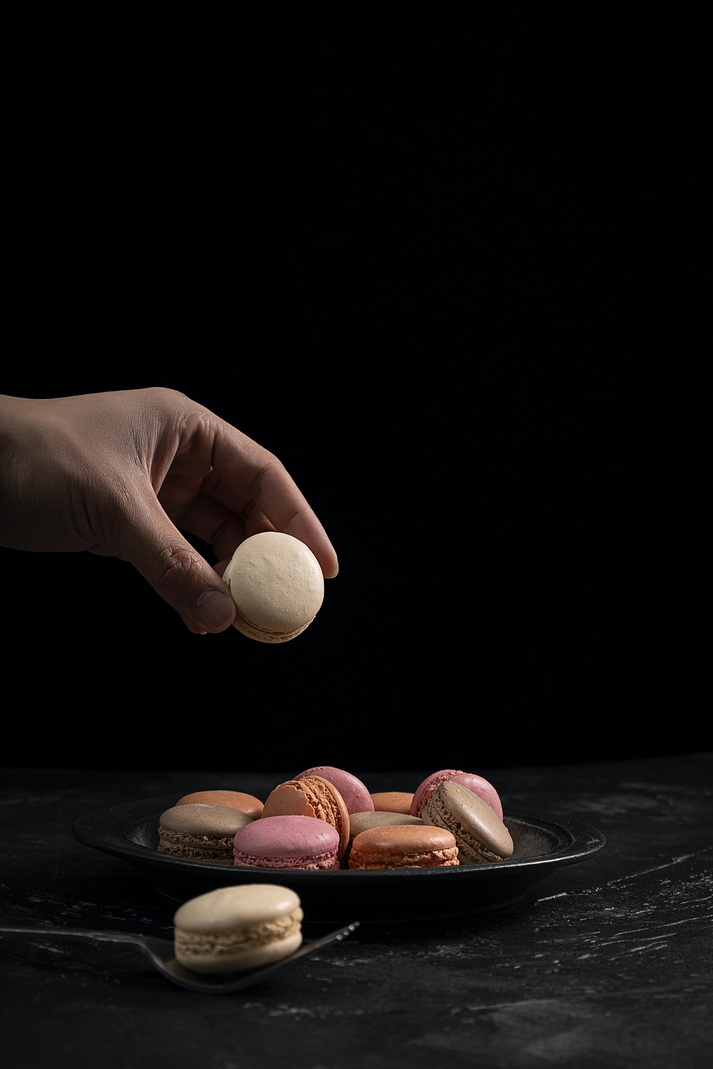手拿甜品马卡龙黑色背景马卡龙图片甜品点心