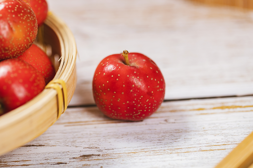 白色木桌上的一颗山楂山楂图片健胃消食水果