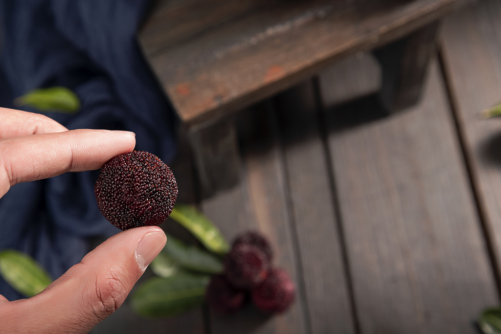 手拿杨梅木桌背景杨梅图片消暑止渴水果